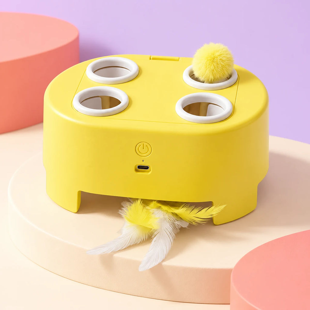 Yellow four-opening cat teaser box with ball and feather attachments shown from another angle