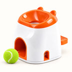 White and orange dog ball reward feeder with a visible green tennis ball on a clean off-white background