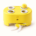 Yellow four-opening cat teaser box with ball and feather attachments on a clean off-white background